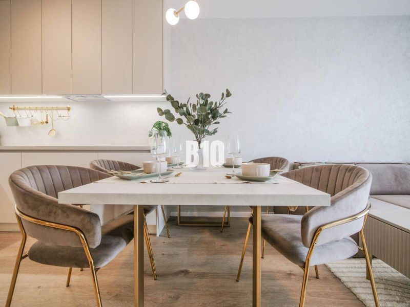 Kitchen and dining area in a 2-room apartment with a wooden decor floor.