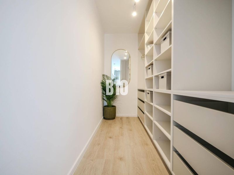 A hallway with shelves and a mirror, a floor with a wooden decor in a 2-room apartment.