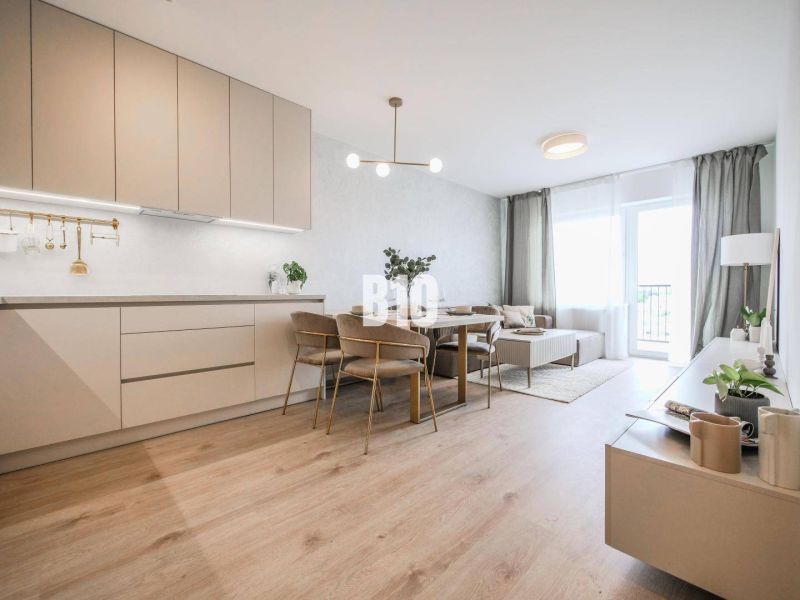 Living room connected to the kitchen in a two-room apartment with a wooden decor floor.