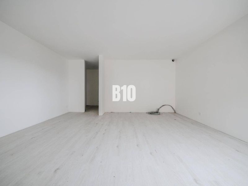 Empty room with white walls and floor, suitable for a studio apartment.