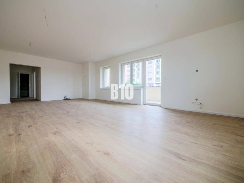 Spacious living room in a 3-room apartment with a wooden decor floor.