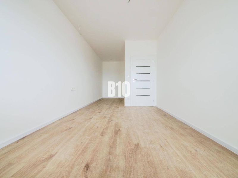Empty room, wooden floor, white walls, interior door of a 2-room apartment.