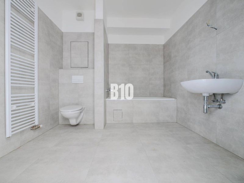 Bathroom with a bathtub, sink, and toilet in a new 2-room apartment.