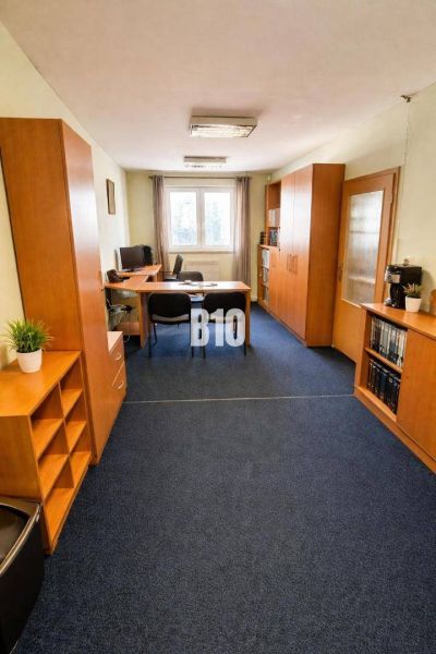 An office with a blue carpet and wooden furniture in a building.