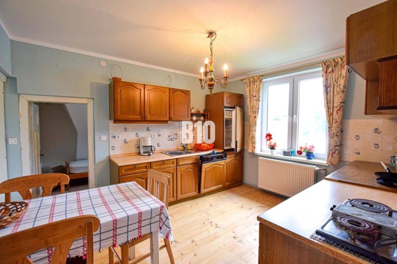 A kitchen in a family house with a wooden decor floor and wooden furniture.