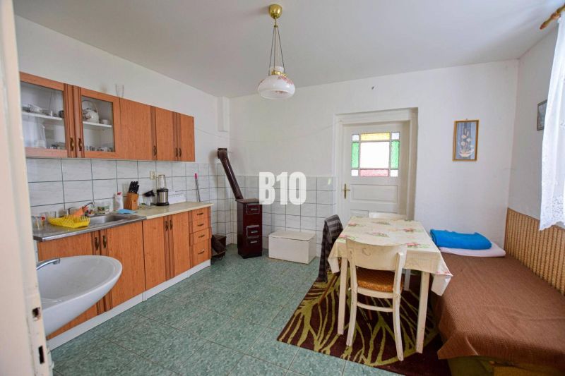 A kitchen in a family house with simple furniture and tiles.