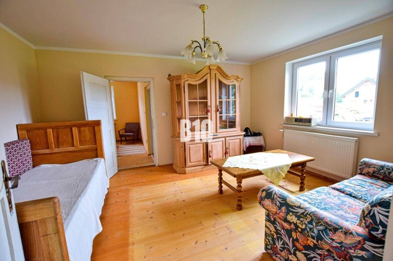 Living room with a sofa, wardrobe, and wooden decor flooring in a family house.
