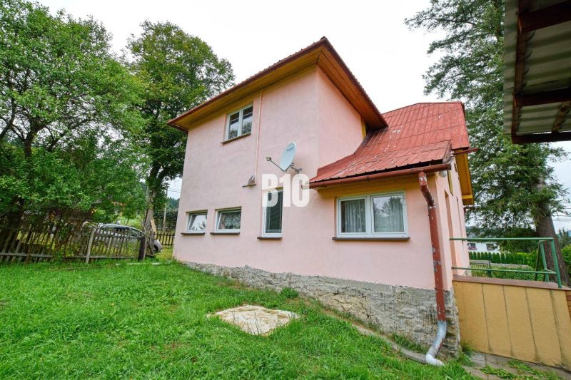 A family house in Makov with a pink facade, a garden, and a satellite dish on the wall.
