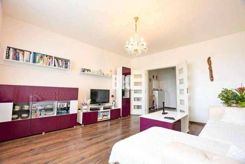 Living room in a 3-room apartment with a wooden decor floor and stylish furniture.
