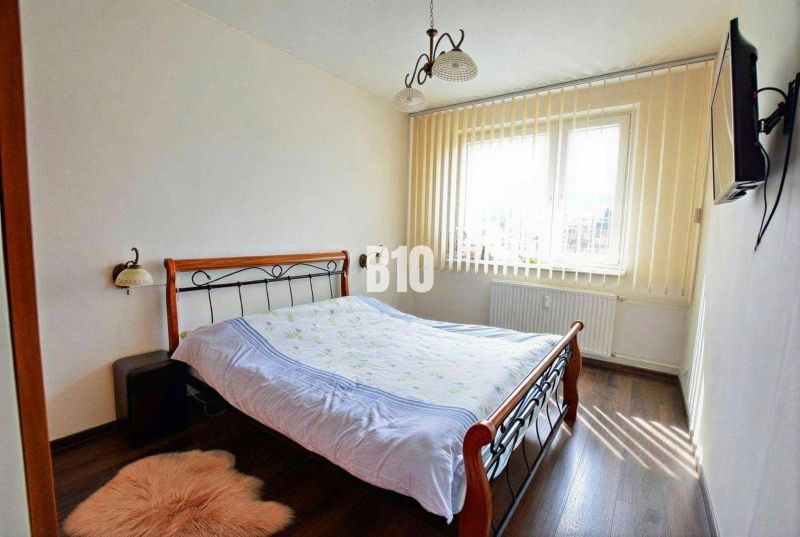 Bedroom with a double bed and a wooden decor floor, 3-room apartment.