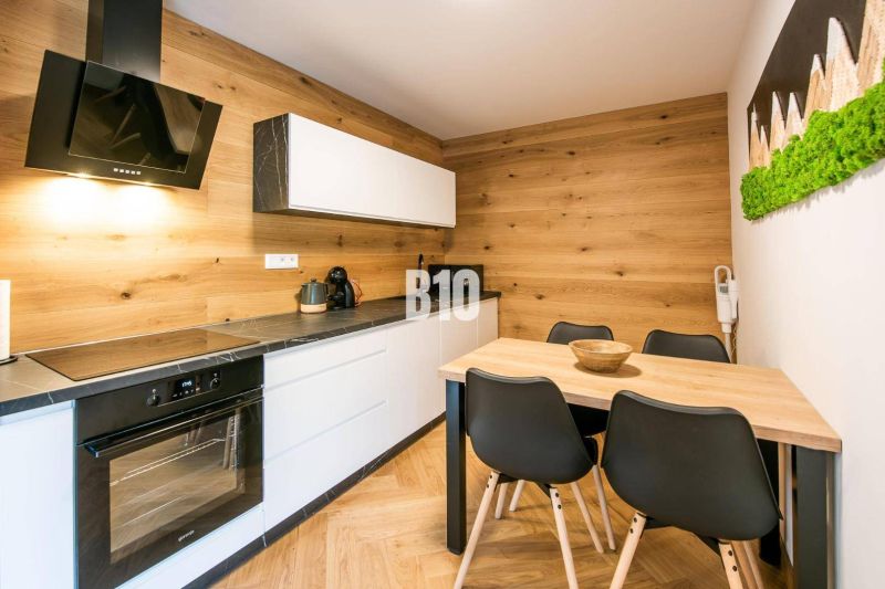 A kitchen with a wooden decor floor in a studio apartment.