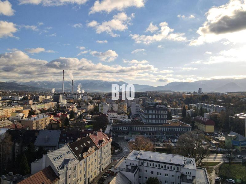 The city of Žilina with a panorama, apartment buildings, and an industrial zone in the foreground.