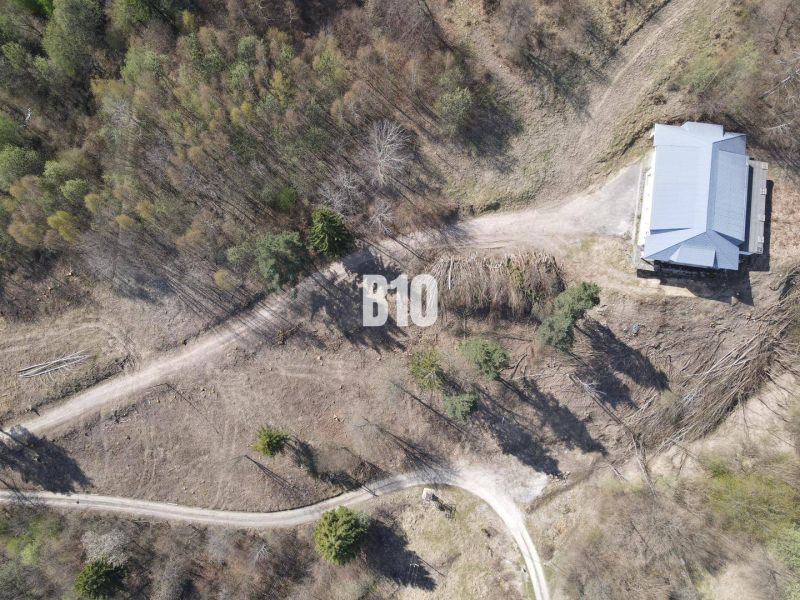 Aerial view of residential plots in Žilina surrounded by forest environment.