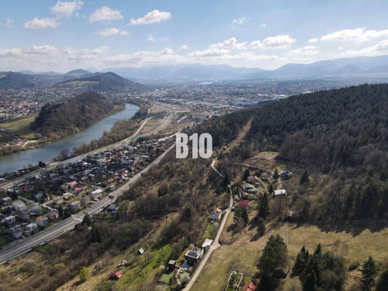 Aerial view of the surroundings of Žilina, residential plots, river, and forests.