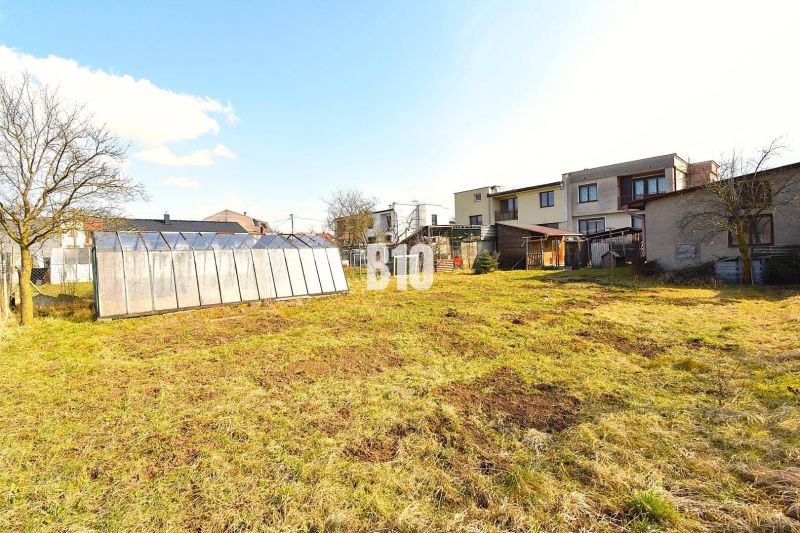 A garden with a greenhouse near a family house in Žilina, grassy area and trees.