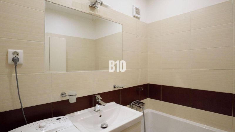 Bathroom with a shower and a sink in a 4-room apartment, cream tiles.