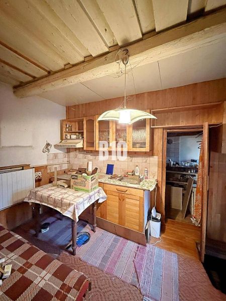 Interior of a family house with a kitchen, dining table, and wooden elements.
