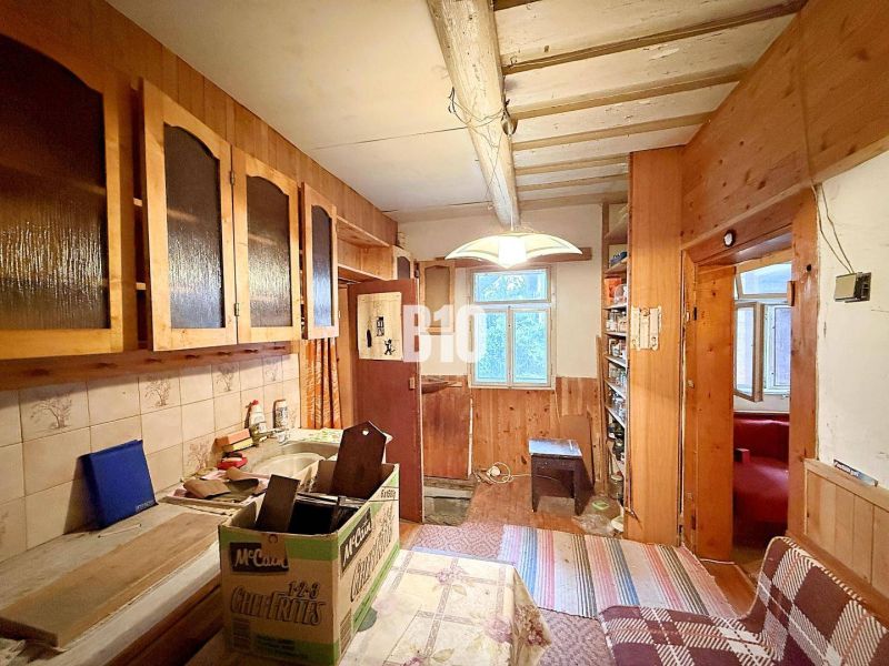 A family house kitchen with wooden cabinets and a tiled wall.