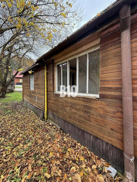 A family house in Kotešová with an older wooden facade, surrounded by autumn leaves and trees.