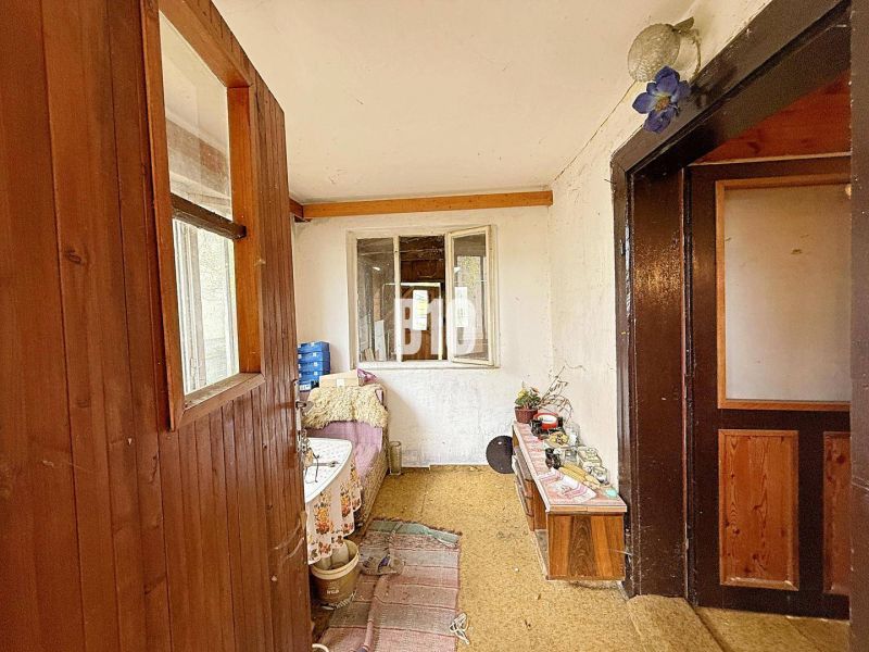 The interior of a family house with wooden paneling and simple furnishings.