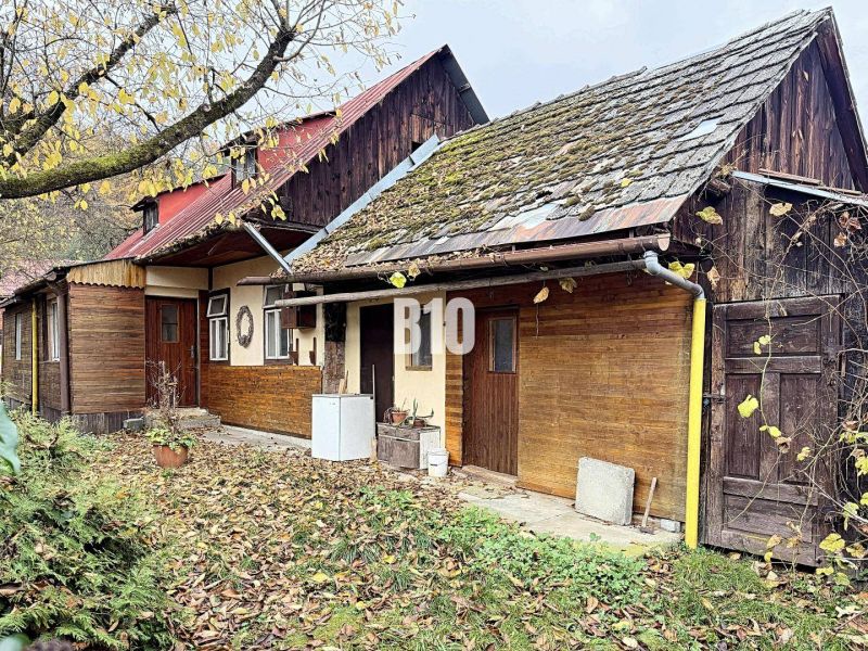 A family house in Kotešová with traditional architecture and autumn leaves in the yard.