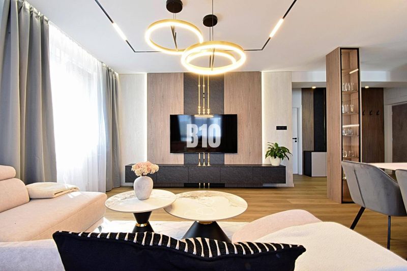 Living room in a 3-room apartment with a wooden decor floor and stylish lighting.
