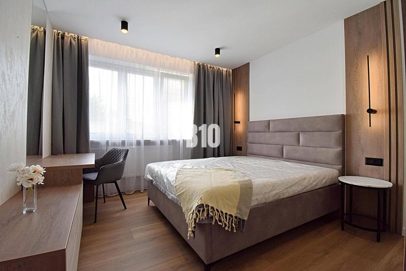 A bedroom in a 3-room apartment with a wood-patterned floor and stylish seating.