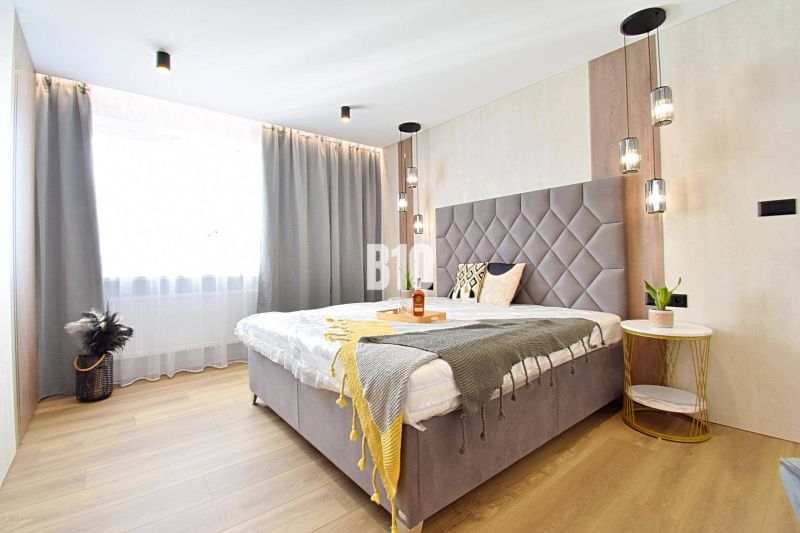 A bedroom in a 3-room apartment with curtains and a wooden decor floor.