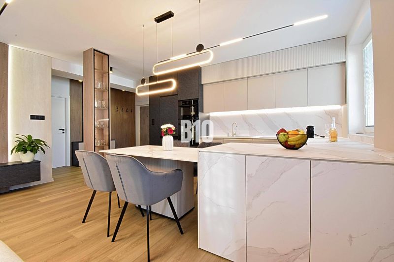 Stylish kitchen in a 3-room apartment with wood-patterned flooring and modern lighting.