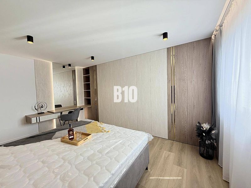 Bedroom in a 3-room apartment with wood-patterned flooring and a built-in wardrobe.