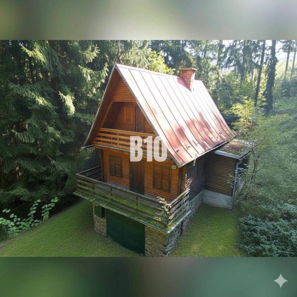 A cottage in Kunerad surrounded by forest with wooden elements and a stone foundation.