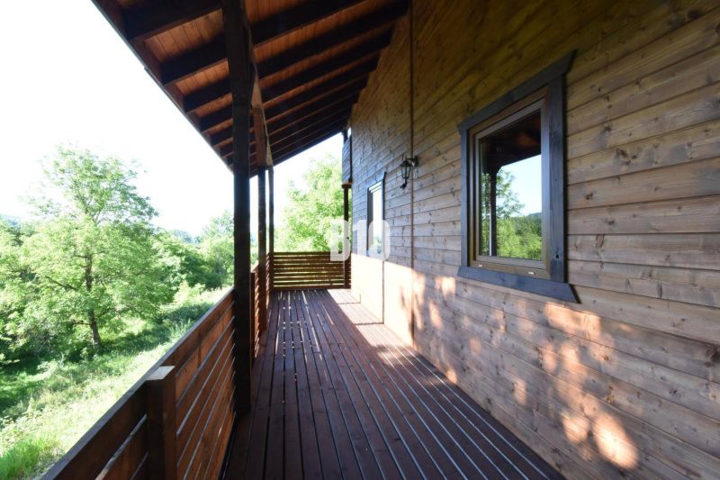 Wooden terrace of the cottage in Bytča with a view of greenery and forests.