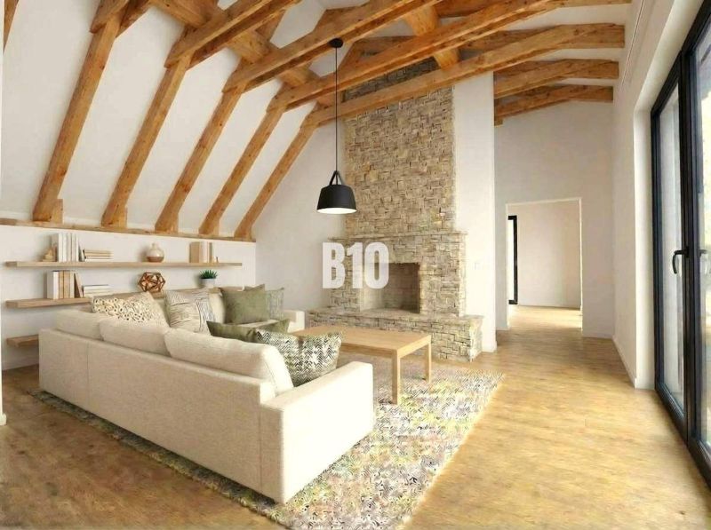 Interior of a cabin with a fireplace, sofa, and wood-patterned flooring.