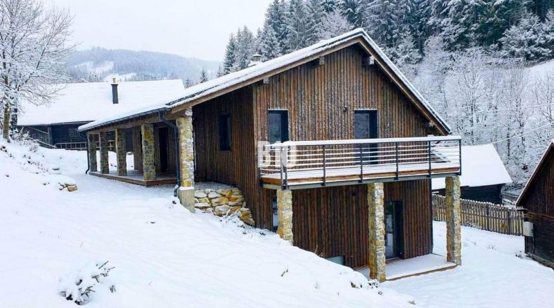 A snow-covered cottage in Horná Mariková surrounded by forest and beautiful winter nature.