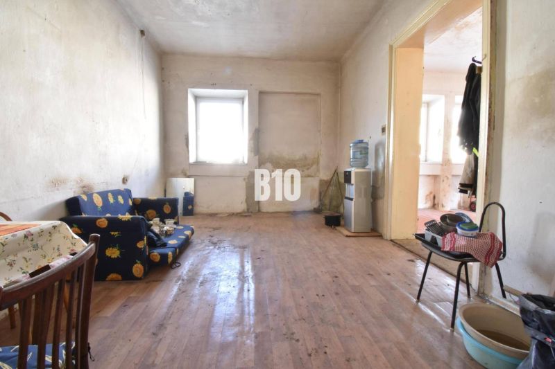 Living room in a family house with a wooden decor floor, older furniture.