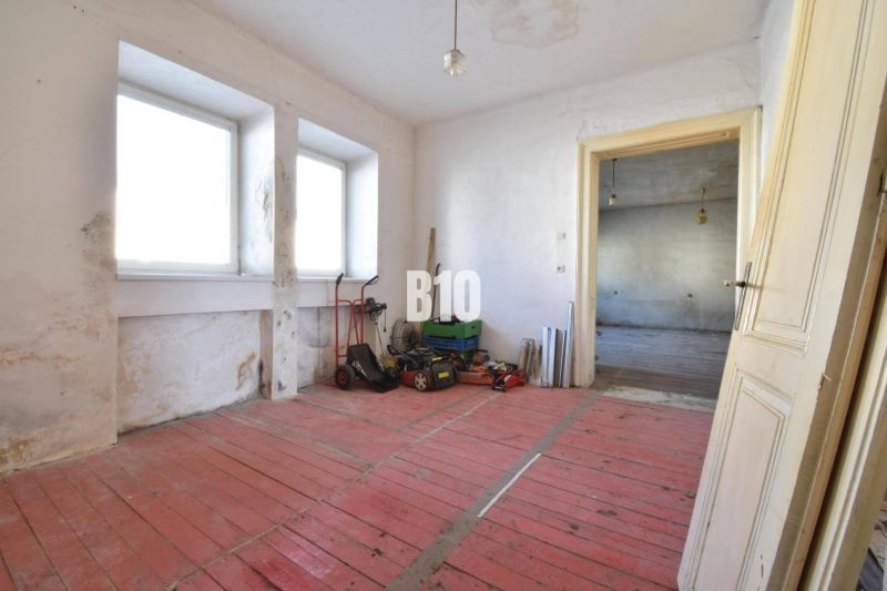 A room in a family house with a red floor and windows, Bytča.
