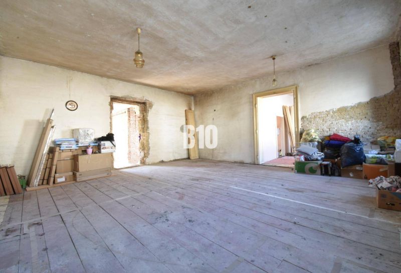 A messy room in a family house with a wooden floor and construction materials.