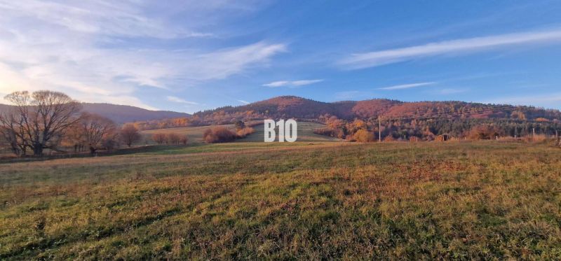 The picture shows an autumn landscape with a meadow and hills suitable for plots and living.