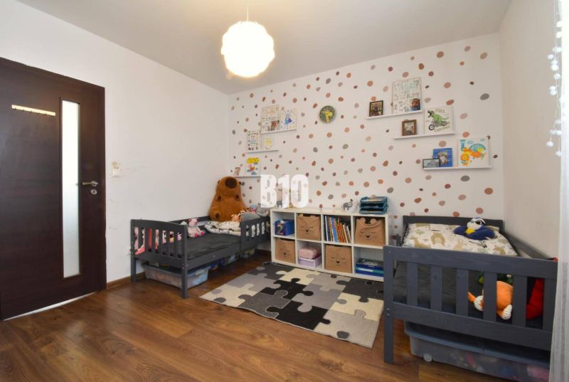 Children's room with cribs, decorative wall, and floor with wooden decor in a 3-room apartment.