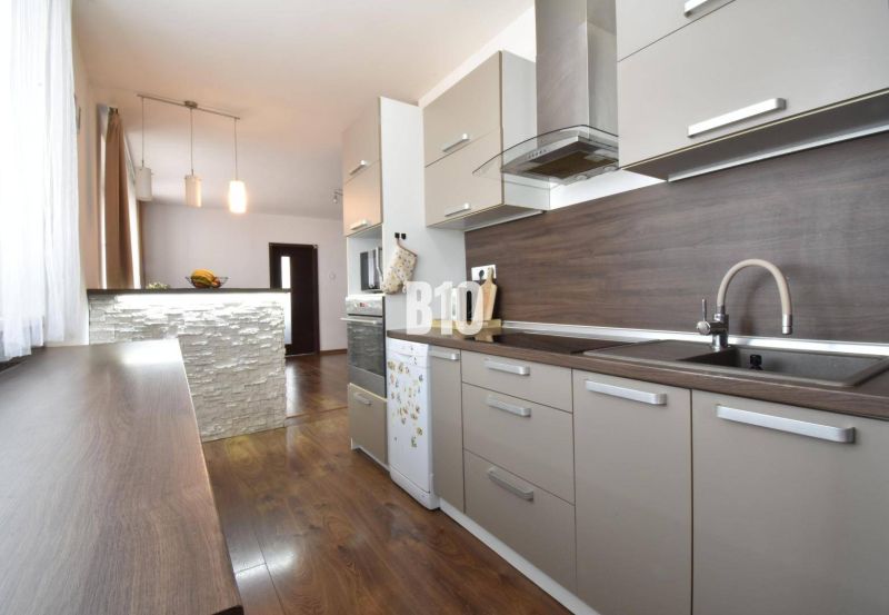 A kitchen in a 3-room apartment with a wooden decor countertop and flooring.