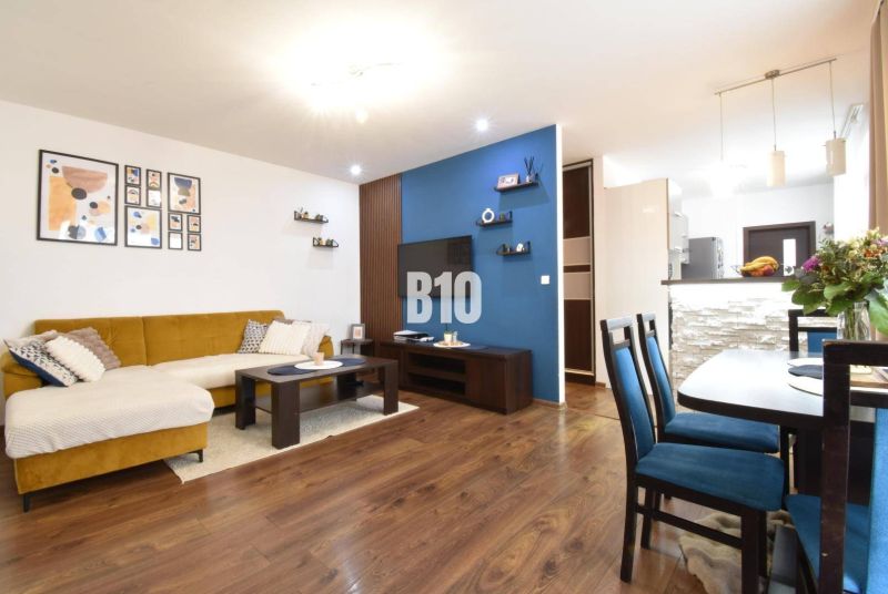 Living room in a three-room apartment with a wooden decor floor and stylish furniture.