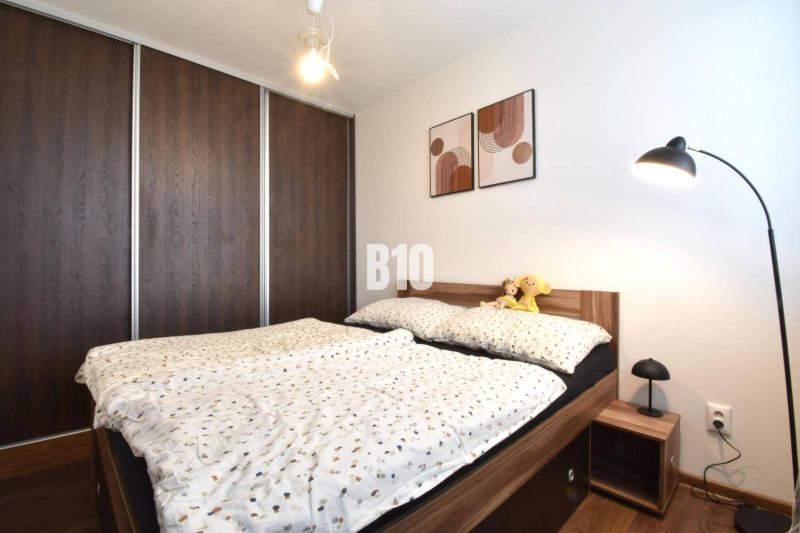 A bedroom in a 3-room apartment with a built-in wardrobe and a bed with a wooden decor.