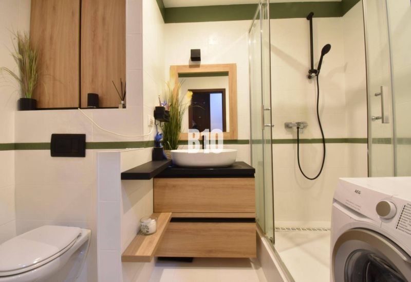 Bathroom in a 3-room apartment with wooden decor and a shower corner.