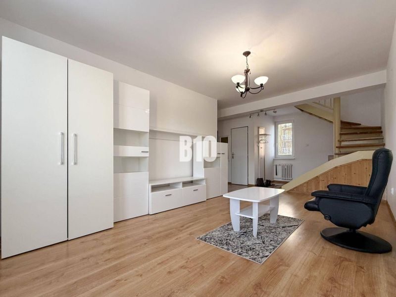 Living room in a holiday apartment with white furniture and a wooden decor floor.