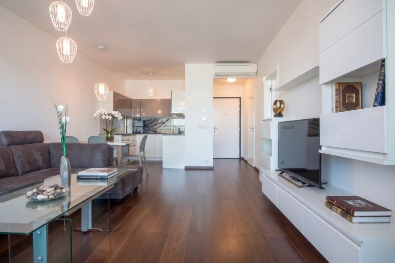 Living room with wood-patterned flooring and a comfortable sofa in a two-room apartment.