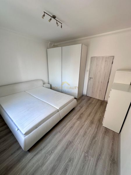 A bedroom in a 3-room apartment with a wooden decor floor and white furniture.