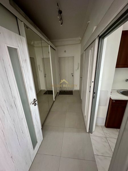 A hallway with tiled flooring and a mirrored wardrobe in a 3-room apartment.