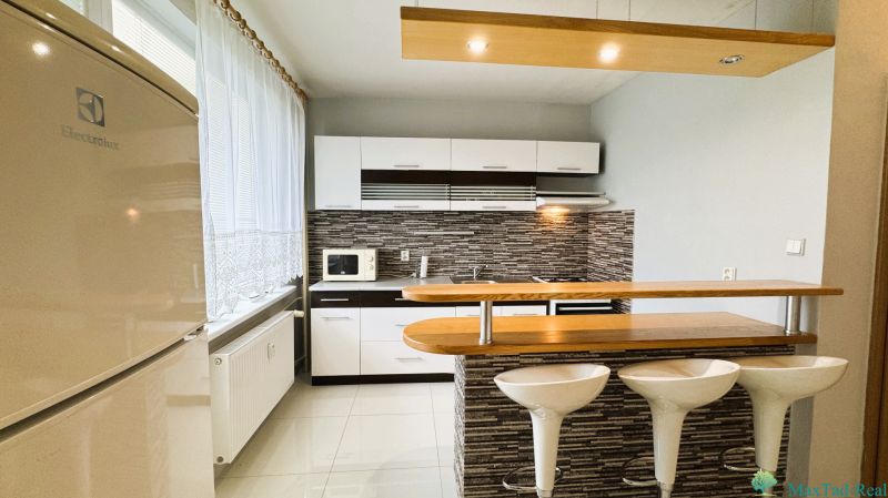 Kitchen in a studio apartment, bright interior, kitchen unit, chairs at the bar.