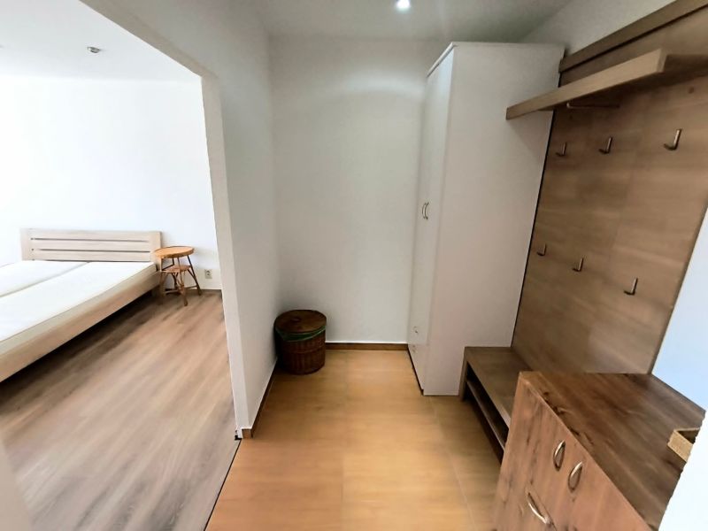 In the 1-room apartment, there is an entrance hallway with a coat rack and a room with a bed.