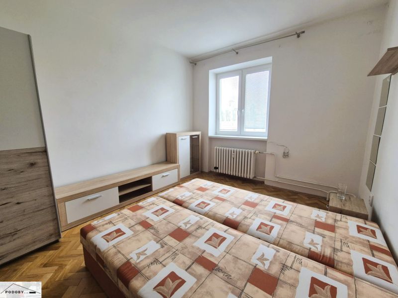 A room in a 3-room apartment with a double bed and a wooden decor floor.